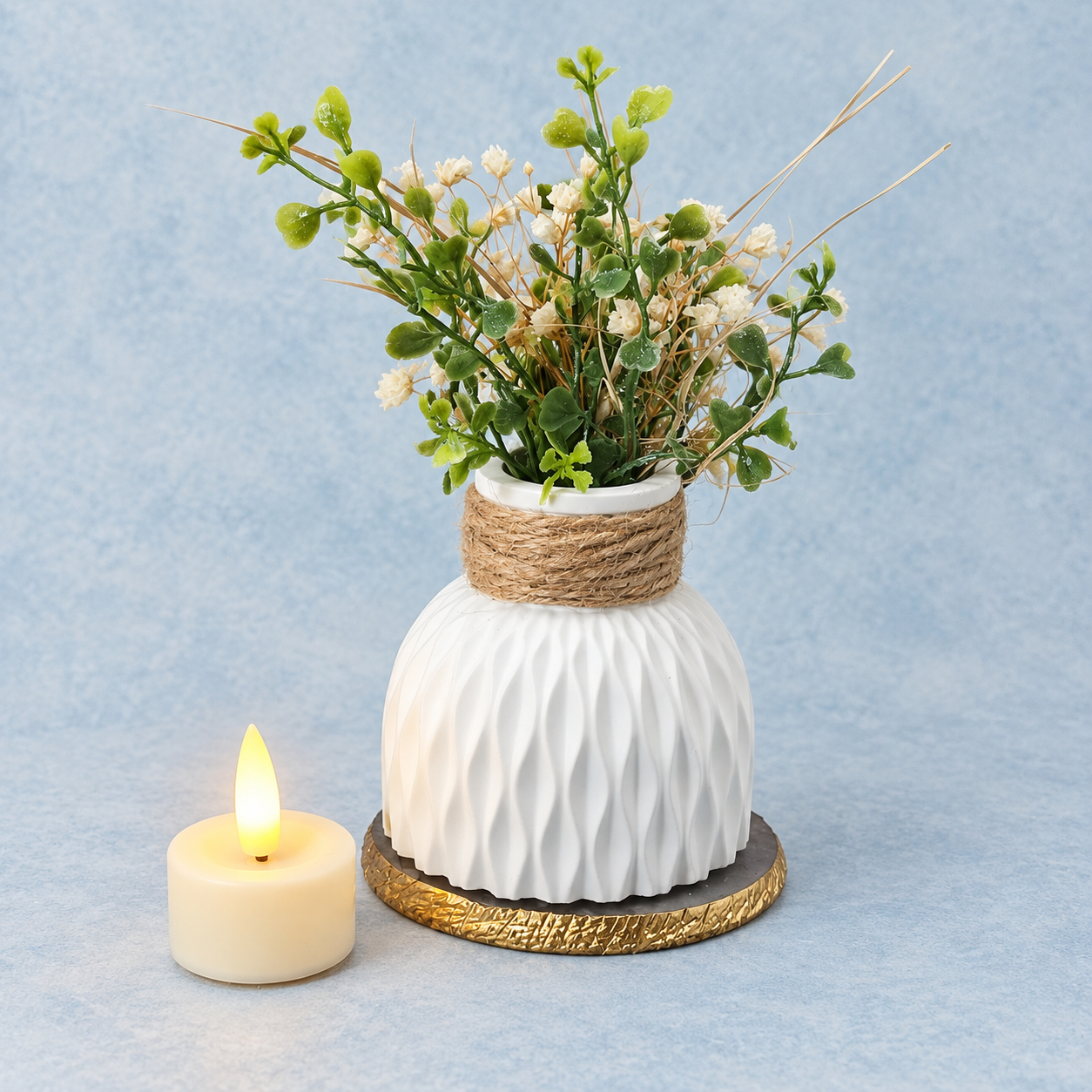 Wit geribbeld vaasje met bloemen en een ledtheelicht op een pastelblauwe achtergrond.