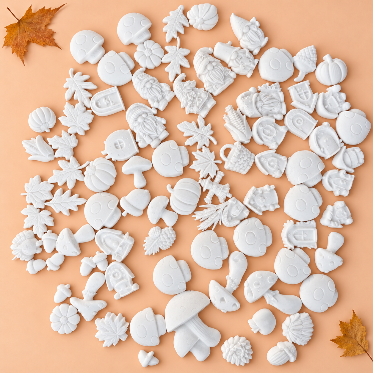 Gemengde witte herfst- en Halloweenfiguurtjes van porseleingips op een perzikkleurige achtergrond.
